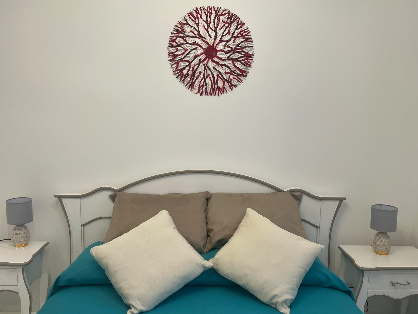 Appartamento Serena - camera matrimoniale con letto turchese e decoro corallo